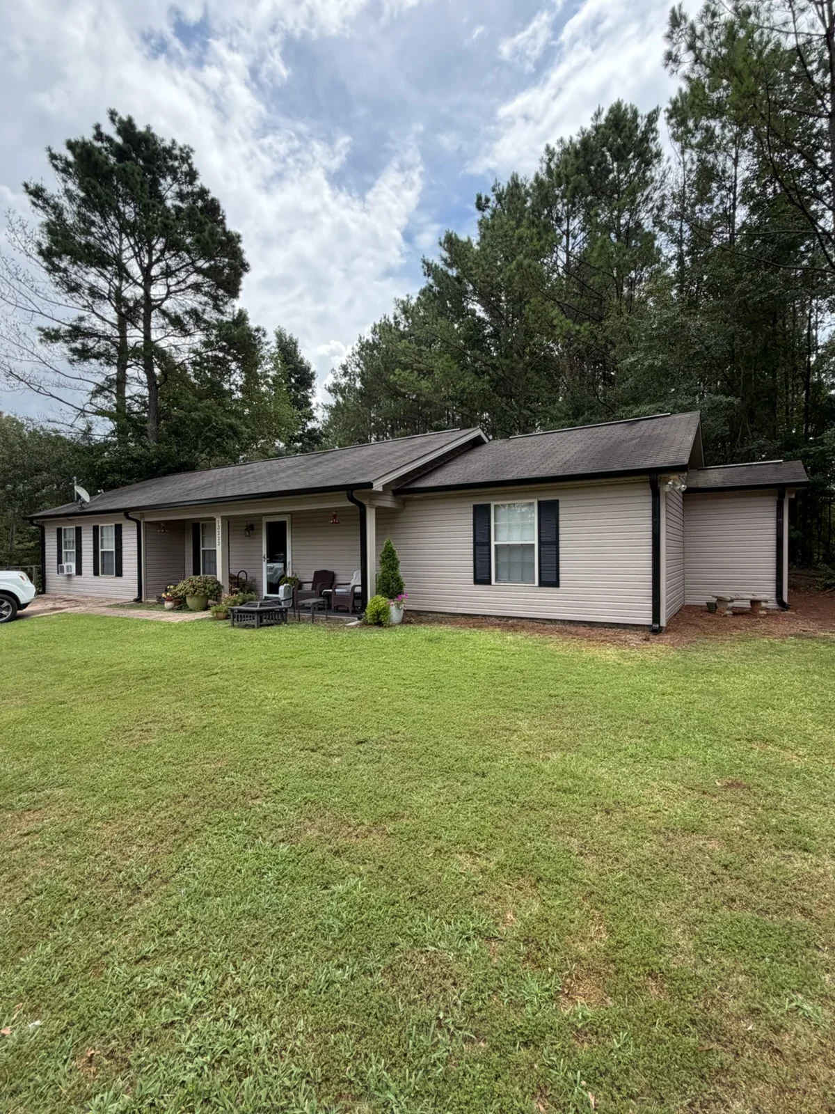 Vinyl-sided home with installed gutters, downspouts, and black shutters